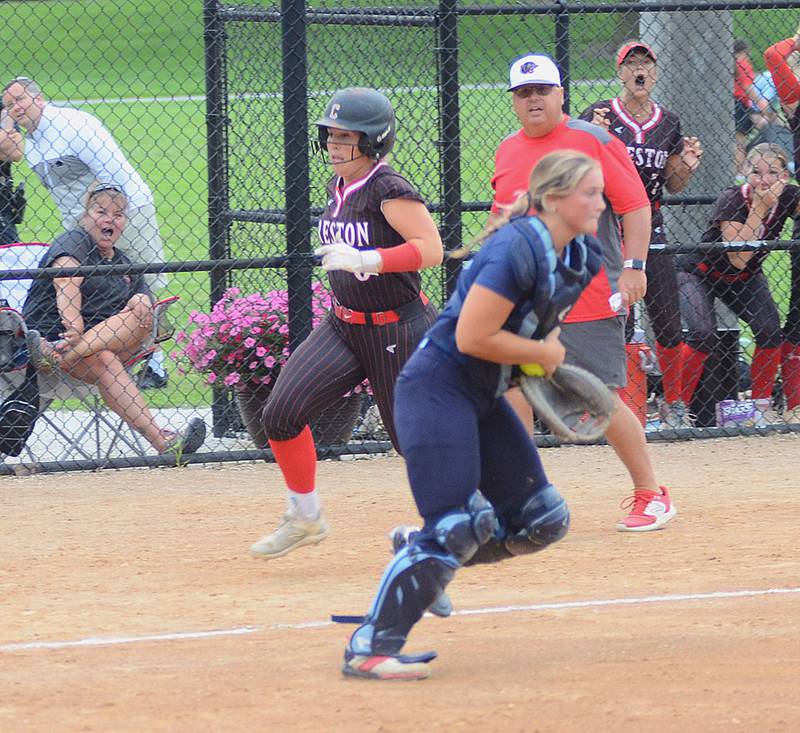 Jaycee Hanson scores the tying run on Ava Adamson's two-run double in the fifth inning made it 2-2 in Creston's 3-2 victory Saturday. Coach Dave Hartman communicates to baserunners near the Panther dugout.