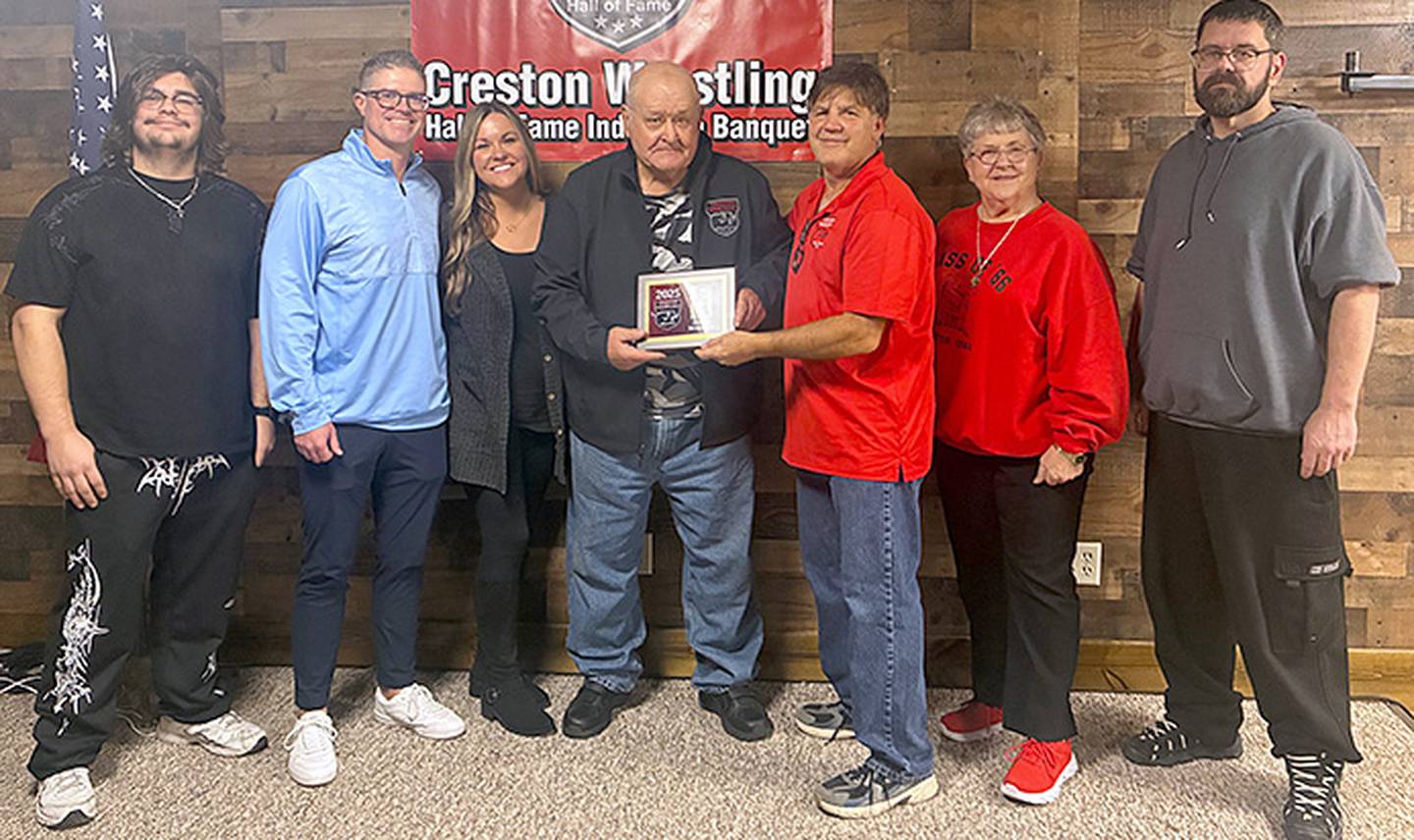 Doug Minnick, Creston class of 1963, receives the Creston Wrestling Hall of Fame plaque from committee member John Walters while accompanied by his family.