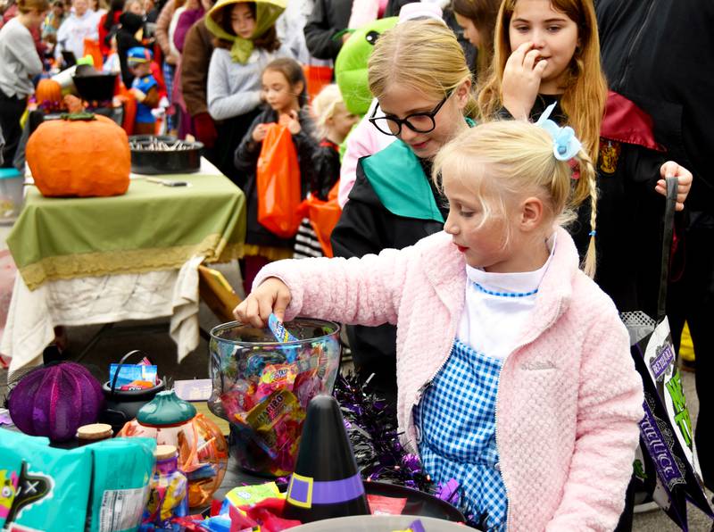 A little Dorothy picks a piece of candy from the Creston News Advertiser booth at Bright Eyes in the Park Saturday. Trick-or-treating is Friday from 5:30 -7:30  p.m. in Creston.