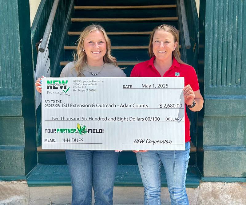 Adair County Youth Coordinator Caroline Savage (right) receives a contribution from NEW Cooperative communications specialist Riley Hisocks to go toward a portion of dues for 4-Hers in the county.