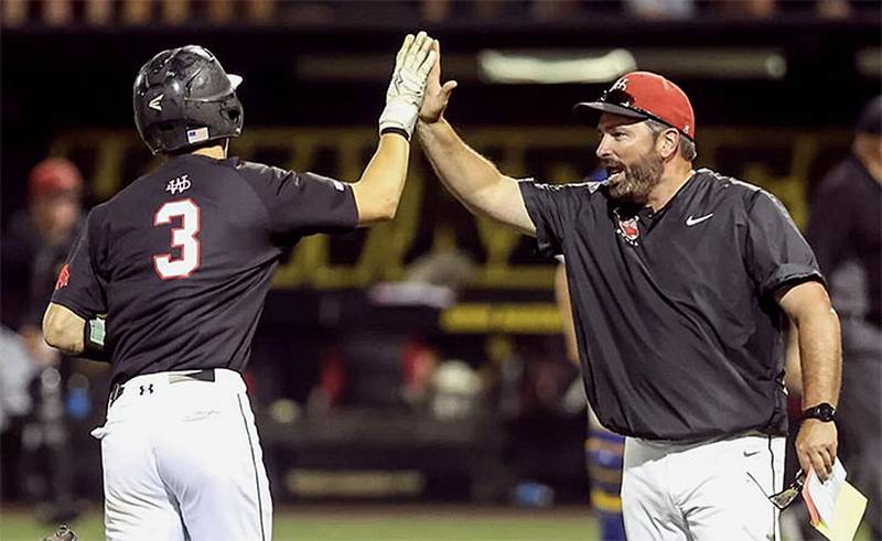 Casey Bryant congratulates a player after a home run during one of his state tournament appearances. The Creston native has coached two state championships.