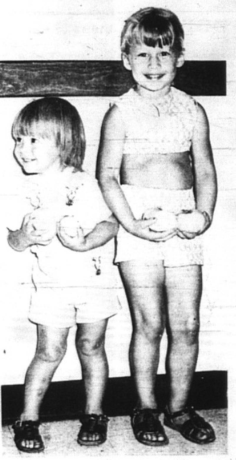 Tami Abell, left, and her older sister, Karrie, display twosomes of toothsome white tomatoes, raised by their grandfather Owne Beaman of Arispe. The sisters are the daughters of Mr. and Mrs Terri Abell of Creston.
