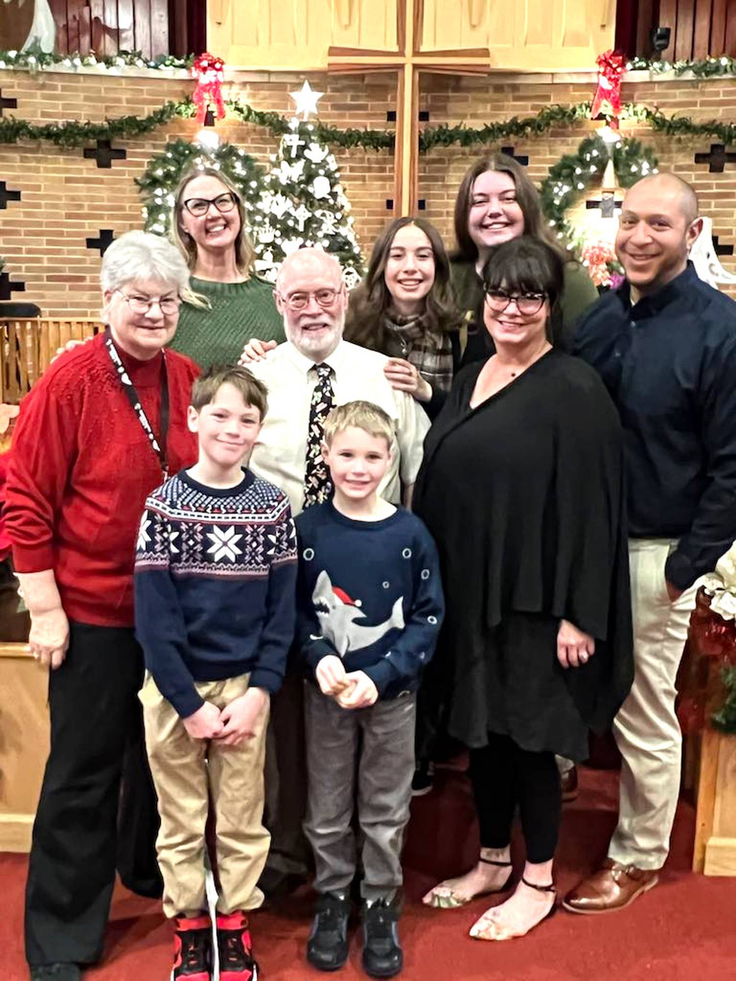 Jim Norman poses with his wife Debbie, his children, children-in-law and grandchildren during Christmas 2024.