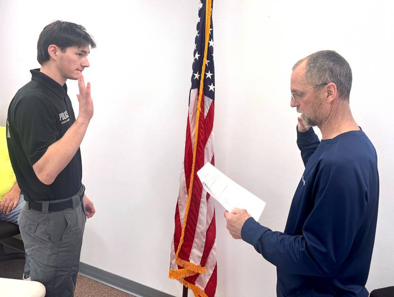 New Greenfield police officer Ben Marsh (left) receives the oath of office from Mayor Brian Fox at a Tuesday, March 10, city council meeting.