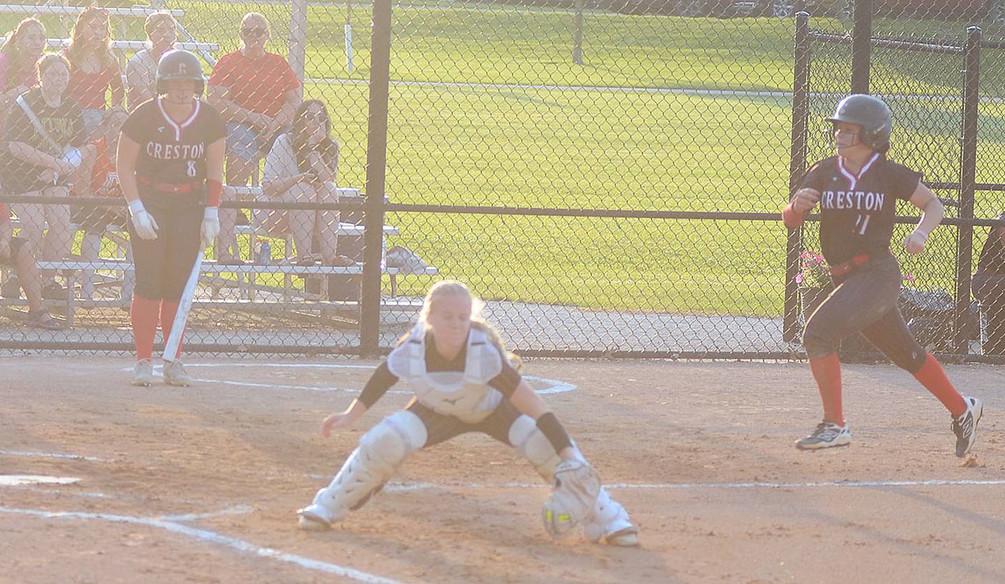 Clarke catcher Alexis Joint catches a throw to the plate as Mila Kuhns rounds the bases on a double and Red Oak error Thursday night. Kuhns hit two doubles in the 14-2 victory.