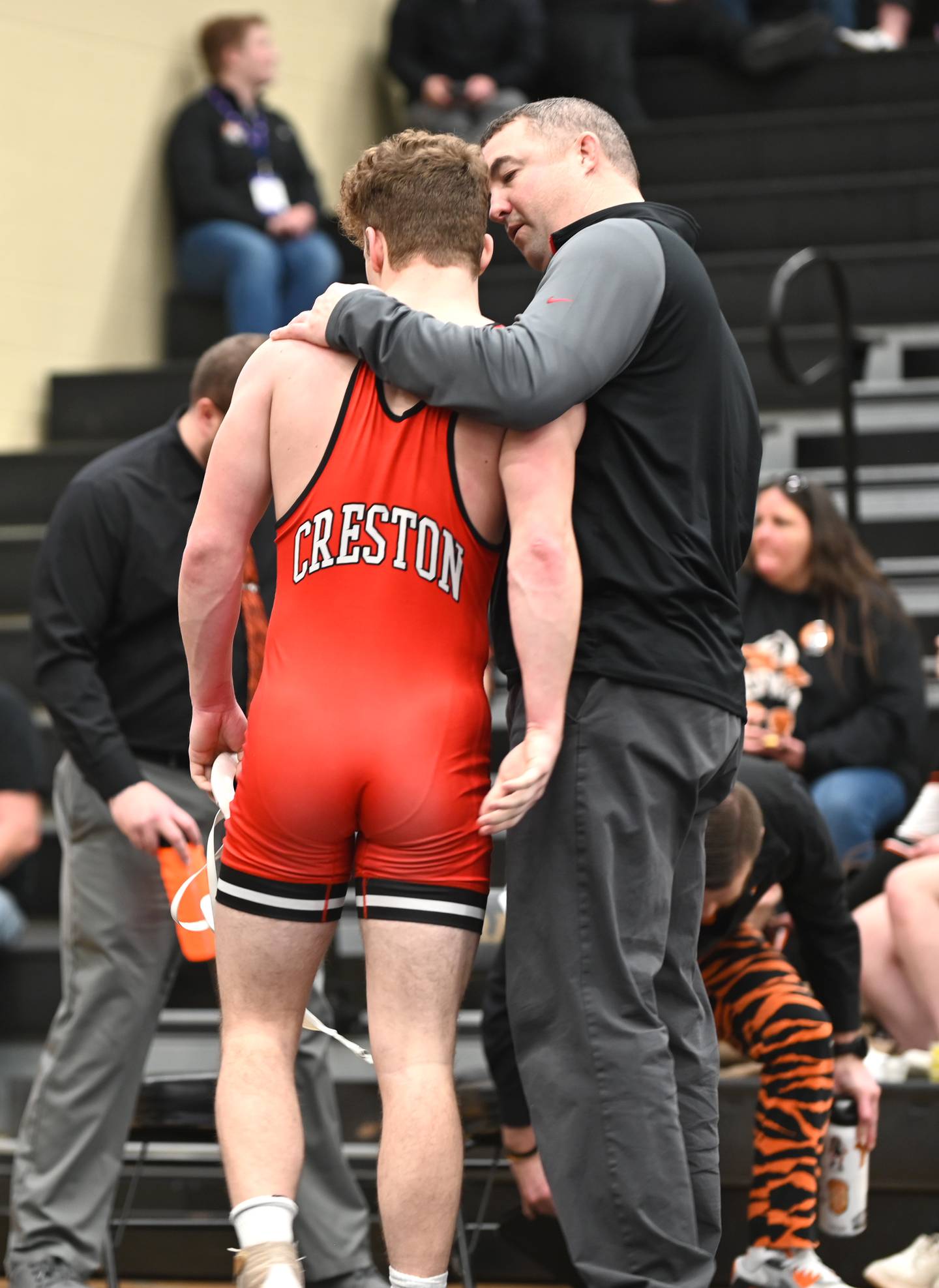 Coach Cody Downing talks to Jackson Pettegrew after he leaves the mat for the final time.