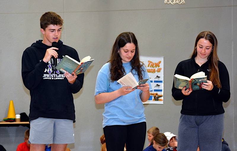 From left, high school seniors Ty Strode, Caroline Britten and Lea Stonebraker read the first few chapters of "A Boy Called Bat" for the elementary students to kick off the "One School, One Book" campaign.