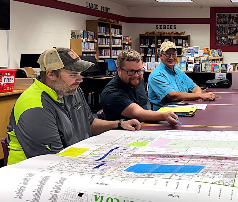 From left, Orient-Macksburg dissolution commission members Alex Maeder, Ryan Frederick and Kevin Blair review the map being discussed during a meeting Monday, Oct. 21.
