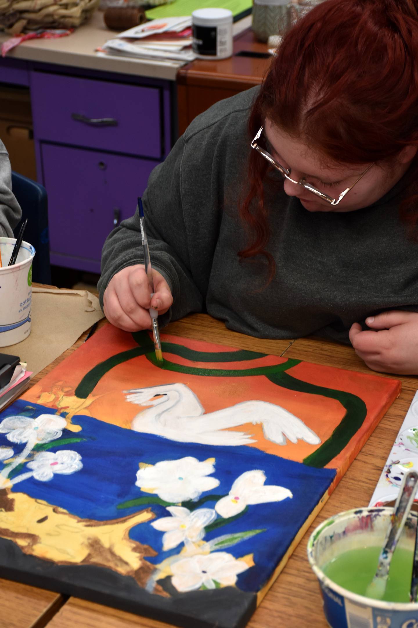 Senior Rowan Kinzie finishes work on her Art Nouveau painting.