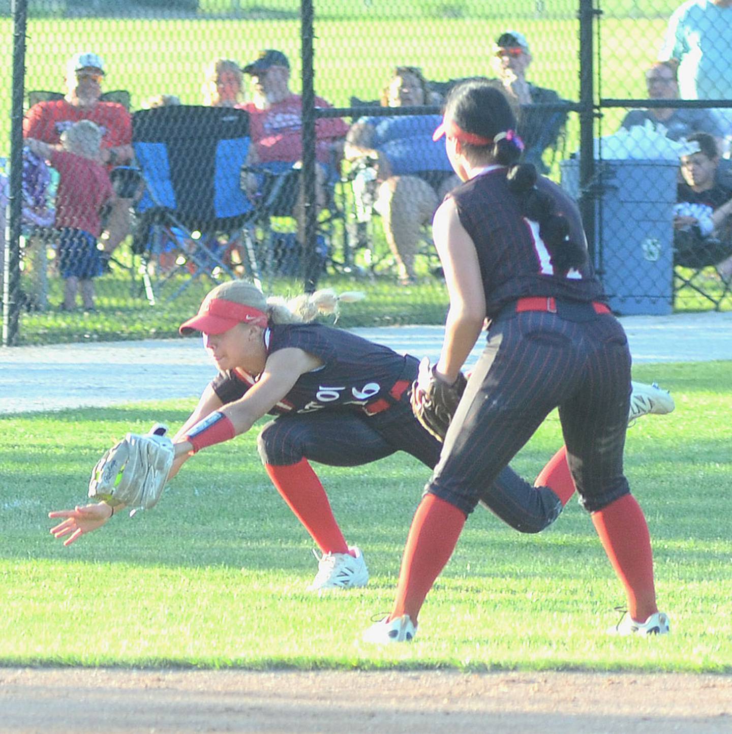 Creston left fielder Cora Smith dives to make a catch on a shallow fly ball as shortstop Mila Kuhns looks on. Smith scored the winning run in a 6-5 victory on Ava Adamson's seventh-inning double.