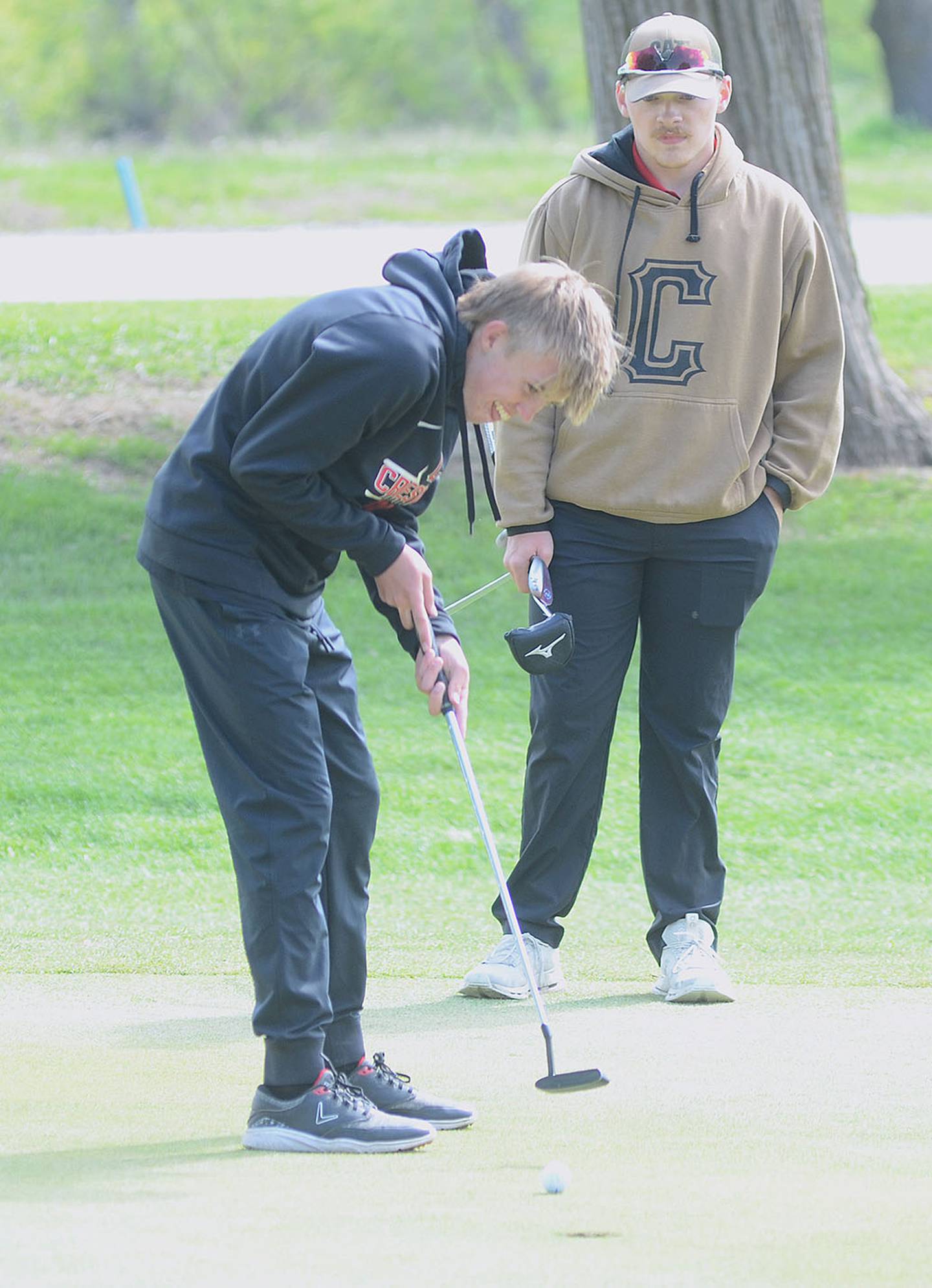 Garrett Troutwine of Creston putts on No. 9 at Crestmoor Friday as teammate Gabe Blazek looks on. Troutwine shot a 44 for the Panthers against Mount Ayr.