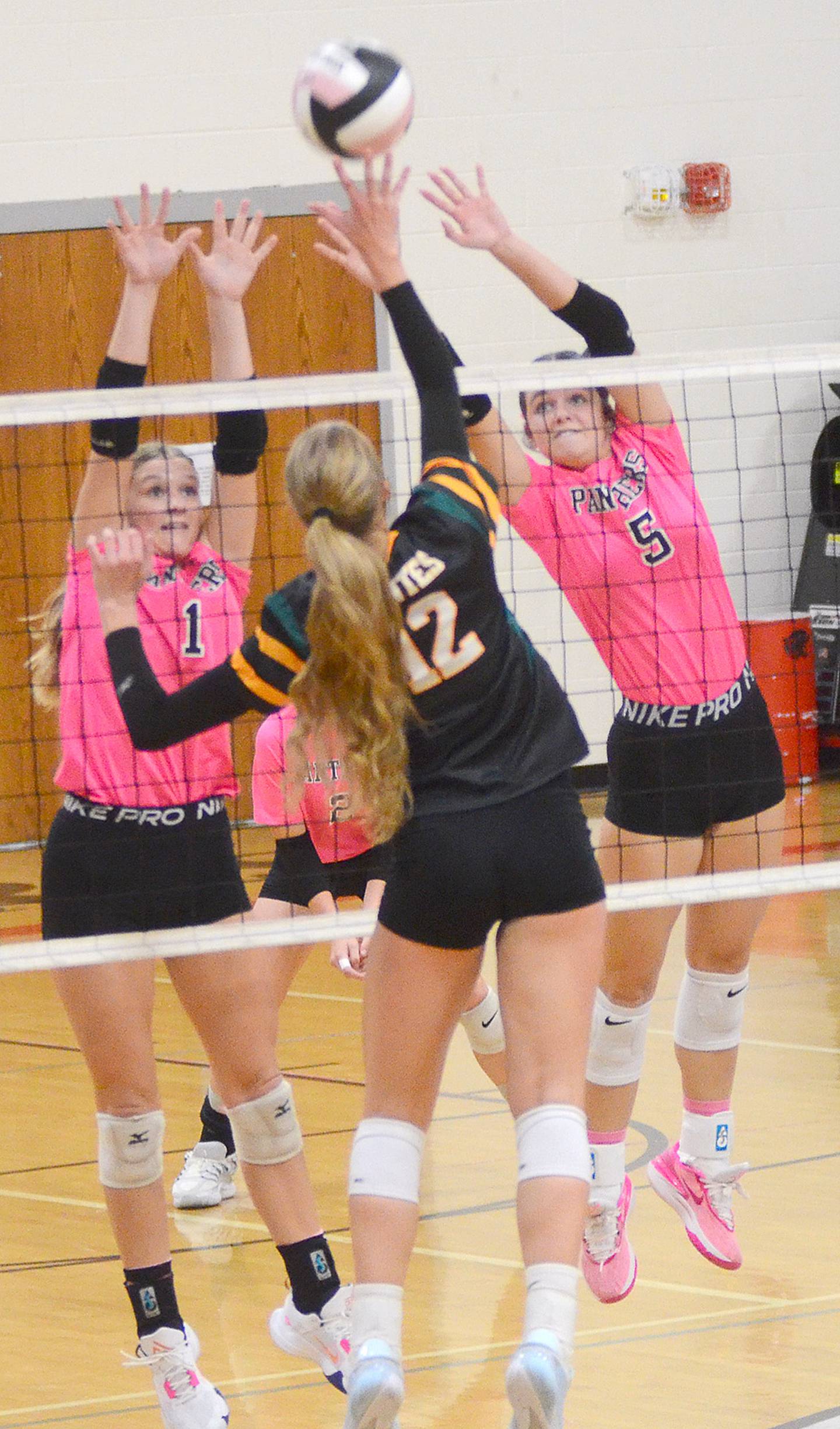 Kadley Bailey (1) and Braylee Pokorny (5) reach for a block against St. Albert outside hitter Naomi Sherrill (12). Sherrill was one of St. Albert's leading hitters with 25 kills.