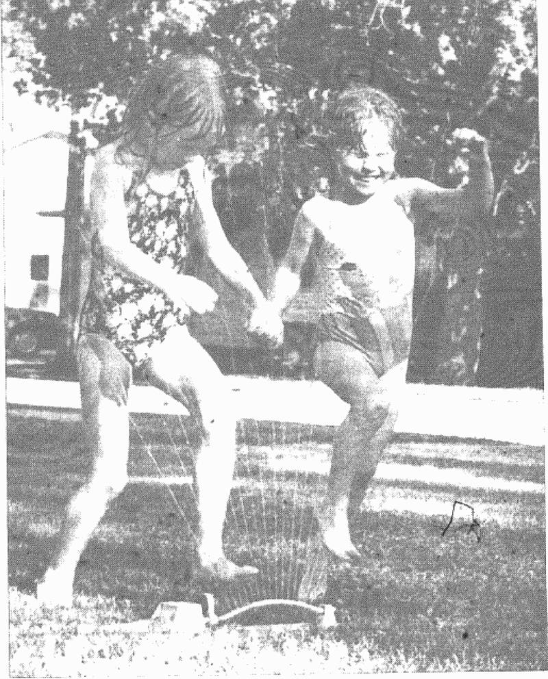 Kelli McKee, 6, and Cassie Mahan, 5, find a fun way to cool off Thursday afternoon. The pair is shown running through the sprinkler at Mahan's home at the corner of Oak and Buckeye streets in Creston.