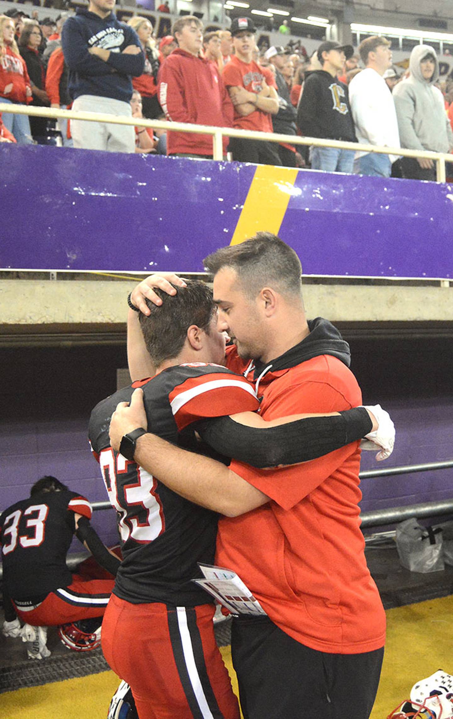 Creston offensive coordinator Garrison Carter consoles wide receiver Brandon Briley after Saturday's 16-13 loss to Bishop Heelan, ending the Panthers' 11-1 season. Briley became the single-season and career receiving leader for Creston after catching 11 passes for 101 yards and a touchdown against the Crusaders. He had 897 yards receiving this year and career yardage of 1,621 with 17 career touchdowns.