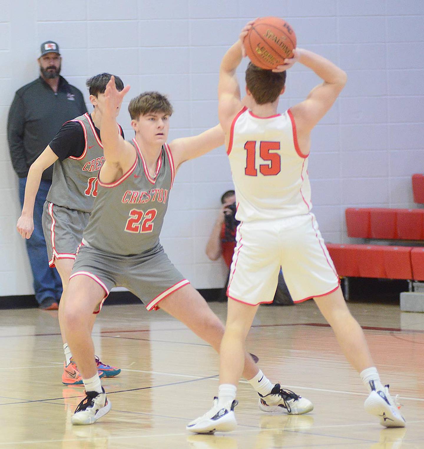 Creston junior Parker Varner (22) defends Harlan guard Jason Erlemeier (15) during Monday's game. Varner made four 3-pointers in scoring 12 points in the overtime win.