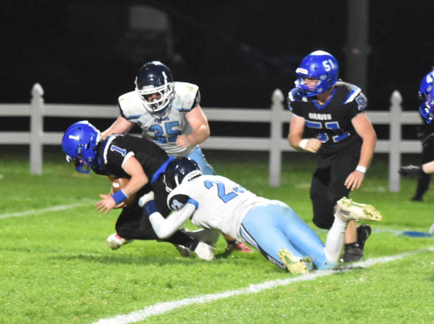 Freshman Coltyn Kelley (No. 23) and senior Brock Jones (No. 35) get to quarterback Brady Boulton in the backfield.
