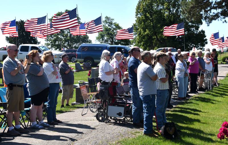 Attendees of the Memorial Day service at Graceland Cemetery Monday stand for the national anthem.