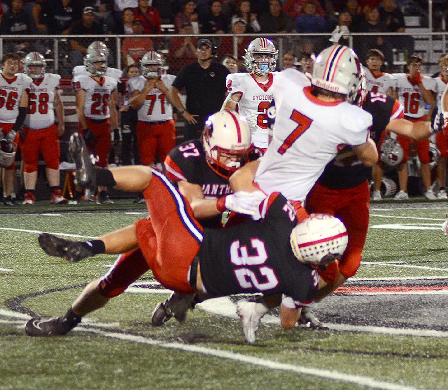 Creston linebackers Austin Evans (32) and Lucas Travis (37) pull down Harlan running back Lucas Francis (7) during Friday's 25-22 victory.