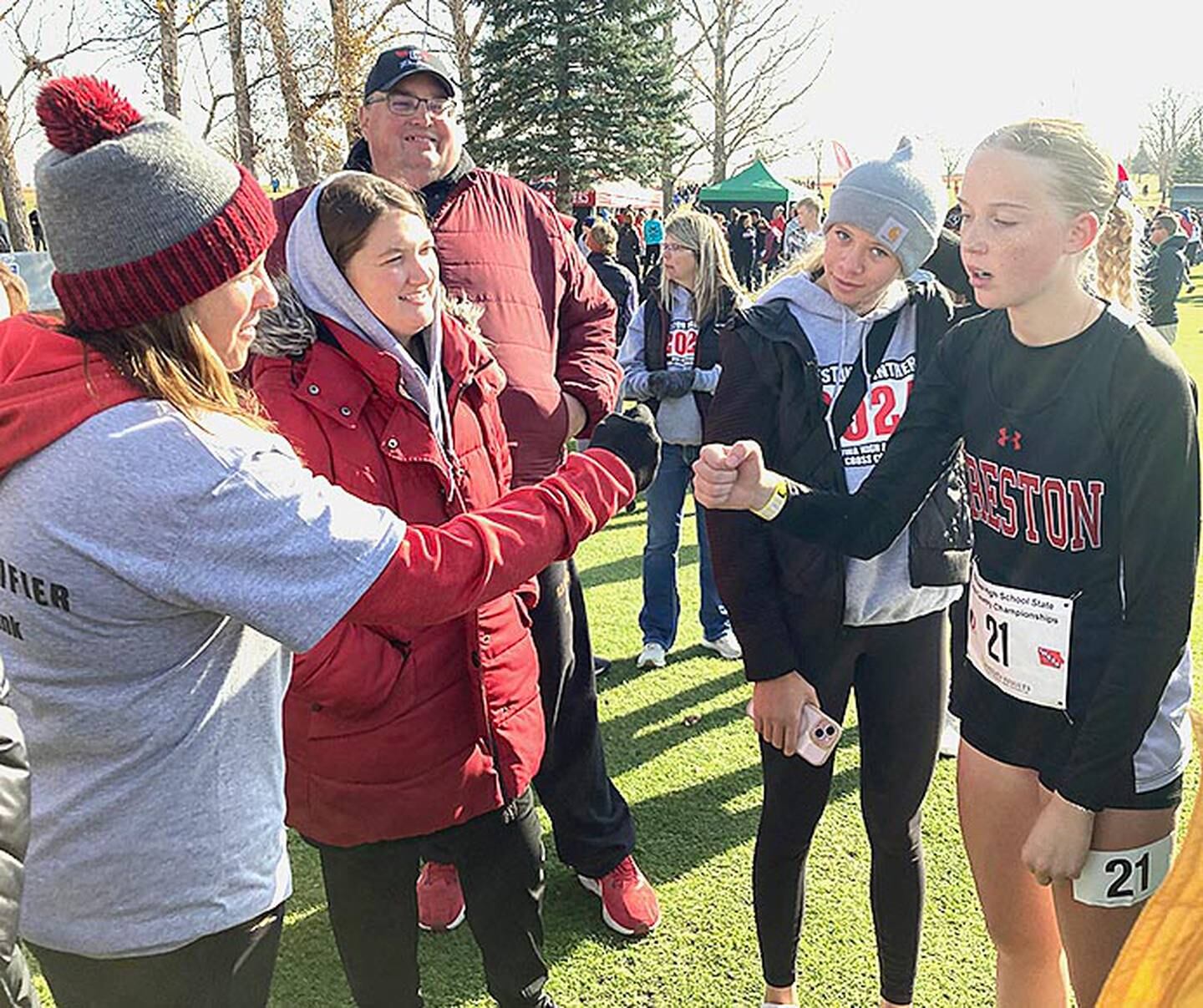 Creston coaches Maggie Arnold and Taylor Tanner congratulate Reese Strunk after the Class 3A girls race at the state cross country meet Friday. Strunk is shown with Creston teammate Cora Smith.