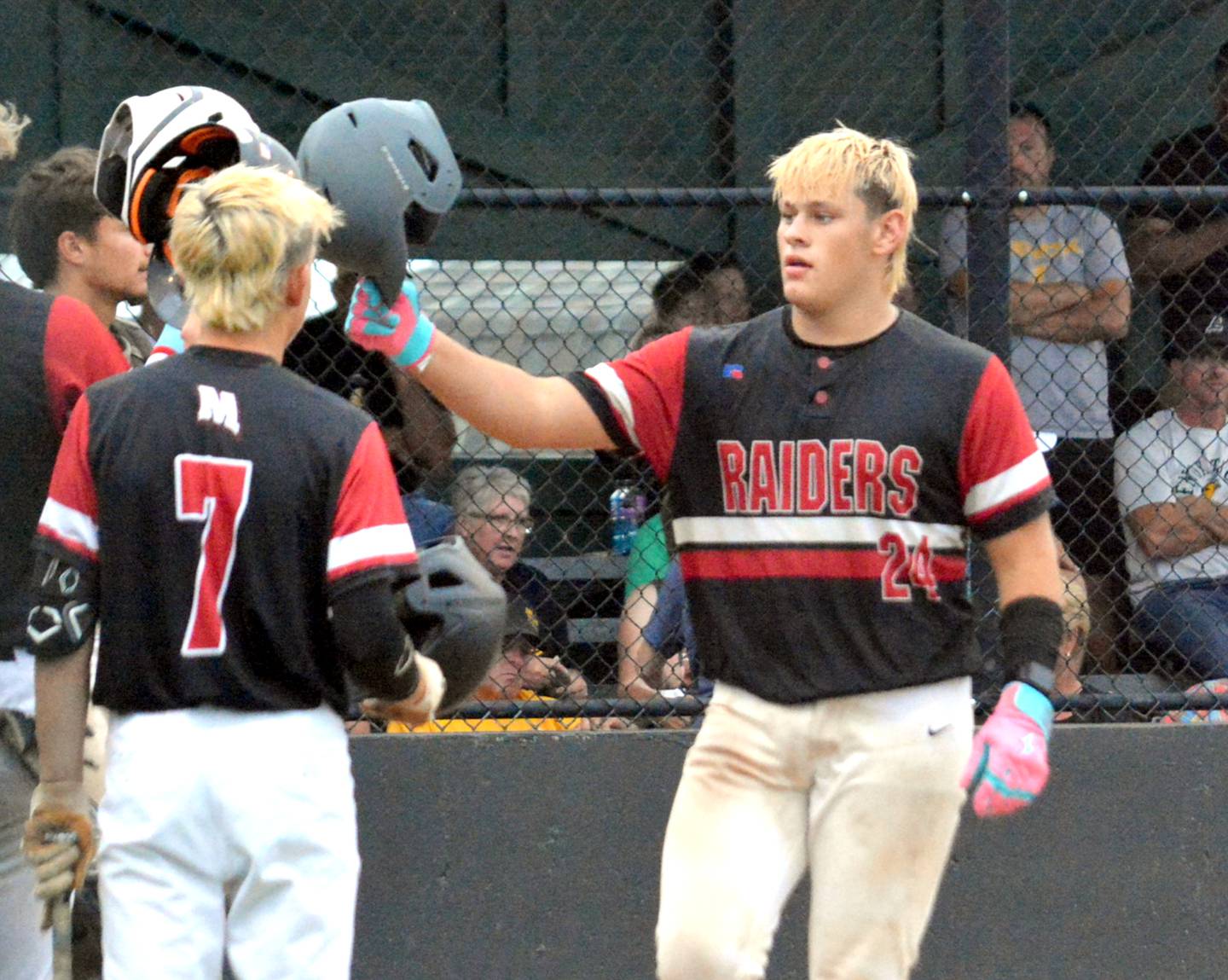 Mount Ayr's Drew Graham knocks helmets with teammates after clubbing a two-run home run over the left field fence against Lenox.