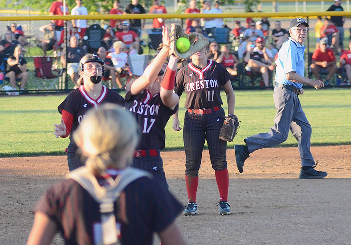 Creston pitcher Taryn Fredrickson catches a popup in front of infielders Evy Marlin and Mila Kuhns (11) and catcher Ava Adamson.