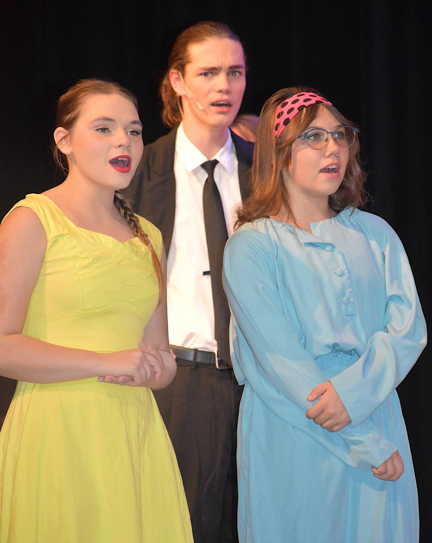 Three students practice during a rehearsal, including Carson Beer, center, who plays the lead Frank Abagnale Jr. From left to right: Mercedez Quinn, Beer, MaKenna Dresback.