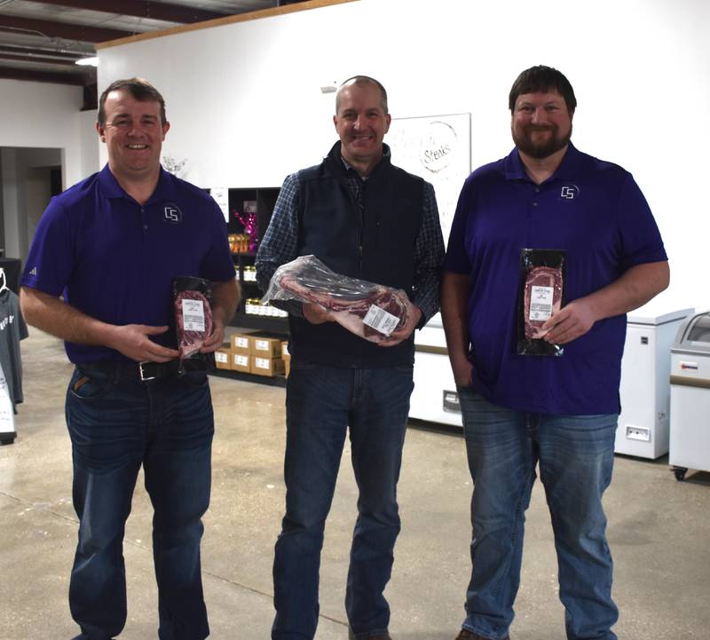 Iowa Secretary of Agriculture Mike Naig poses with Chad Rieck and Kyle Weaver, two of the Champion Steaks owners, during a visit to Creston last Friday.