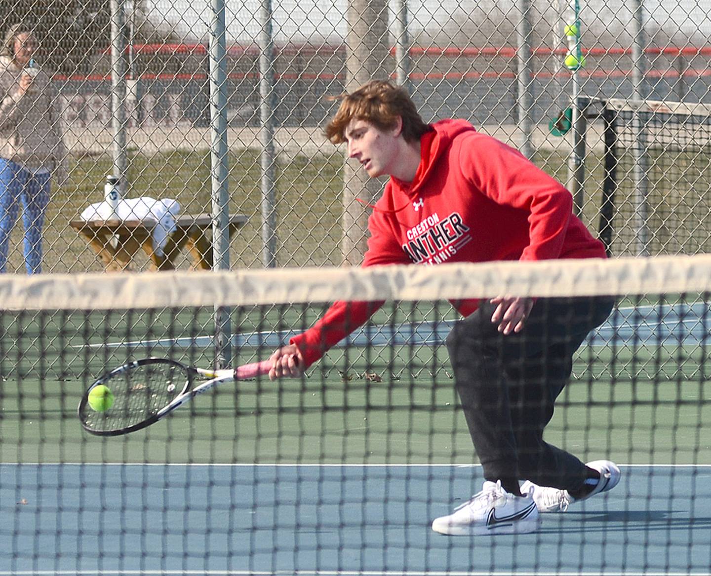 Creston senior Conner Wiley reaches to return a shot against Audubon in the No. 1 singles match Friday.