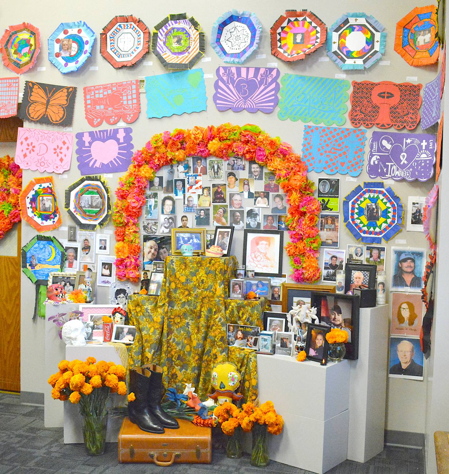 A shrine constructed using pieces from across Creston Community School District. Portraits of loved ones create a collective display honoring those who passed.