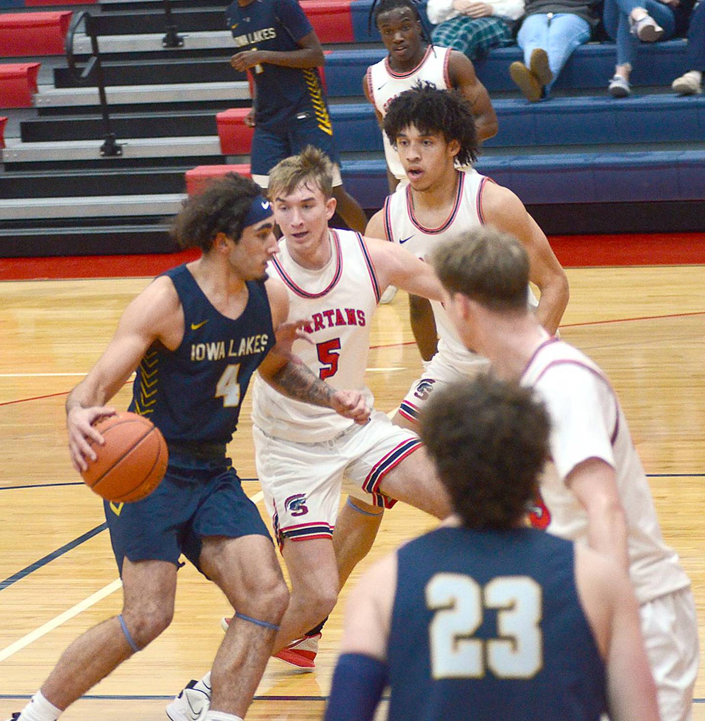 Patrick Worrell (5) and Southwestern teammates Andrew Scoggins (rear) and Bogdan Cret (right) converge on Sam West of Iowa Lakes. Worrell sank a late 3-pointer to cap a 17-point day and give Southwestern a 60-57 lead.