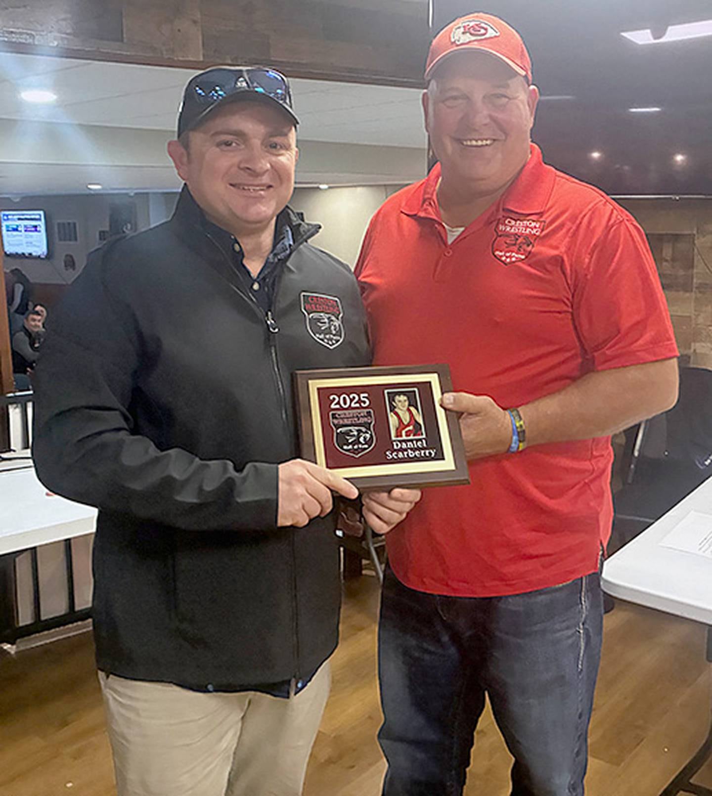 Chuck Hulett of the Creston Wrestling Hall of Fame committee presents the 2025 Hall of Fame plaque to Daniel Scarberry, state champion for Creston in 2004.