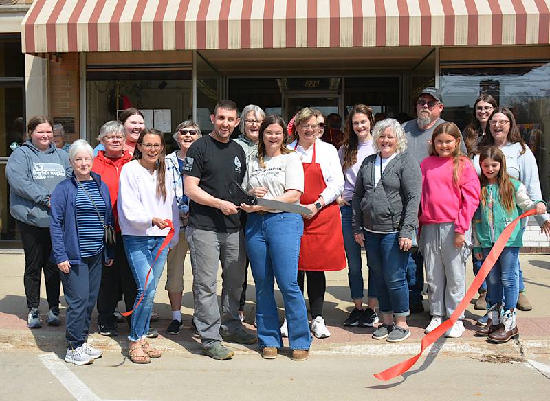 Vendors, friends and family help Zach and Kendra Daniels (middle) cut the ribbon on Greenfield Mercantile, in the building most recently home to J's Variety.