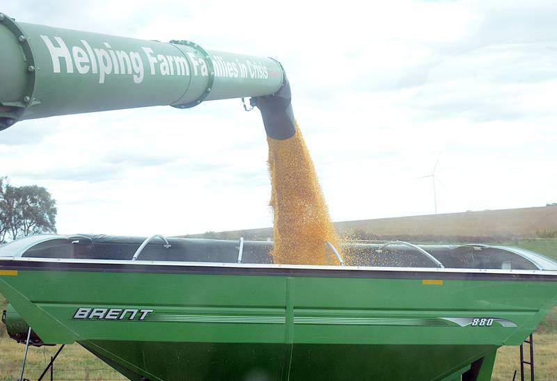 Corn flows from an auger on a combine that says it all ­— “Helping Farm Families in Crisis,” which is the non-profit organization Farm Rescue’s motto. Farm Rescue came to help Mark Lents harvest corn last week. Lents, who was diagnosed in February with stage 4 cancer, had his third surgery of this year this week.