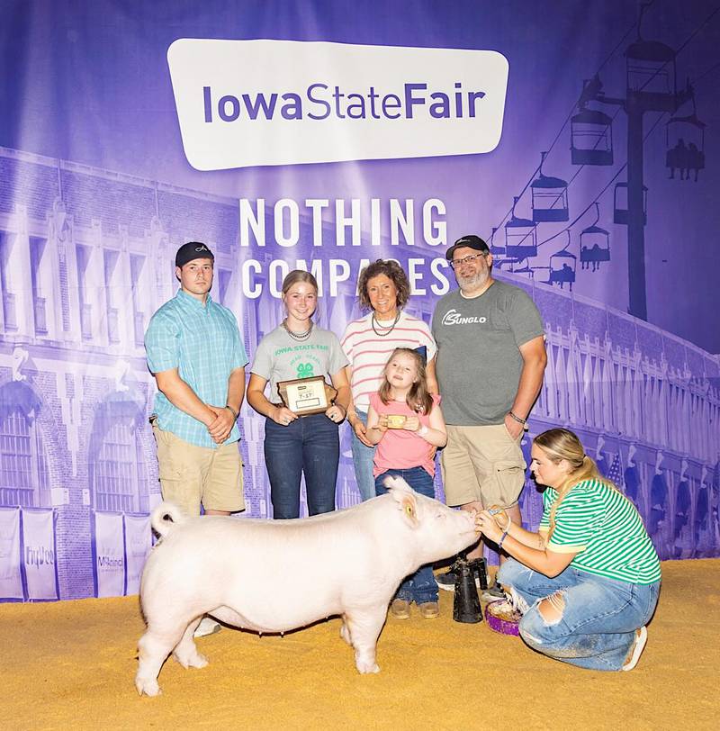 Taylor Rohrig poses with her pig, her plaque and her family after winning senior showmanship at the Iowa State Fair.