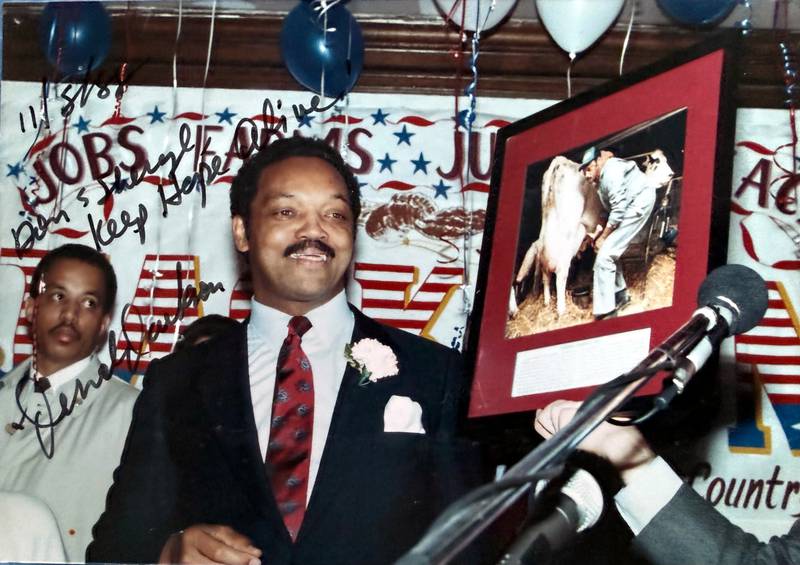 Greenfield resident Dan Dickinson captured this photo of Rev. Jesse Jackson during an appearance of his at the Old Hotel (now Hotel Greenfield) during his 1988 presidential campaign. The framed photo in the picture, held up by Jay Howe, is of Jackson milking a cow on the Dixon Terry farm outside of Greenfield.