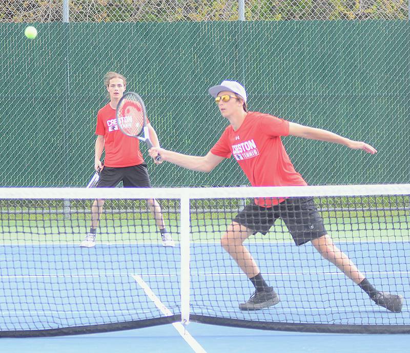 Creston's Tim Bartlett reaches to volley at the net while teammate Carson Beer covers the baseline during doubles action Thursday at Osceola. Bartlett and Beer fell to Clarke's Easton Brokaw and Jonathan Galvez, 8-3. Beer was one of two Creston singles winners.