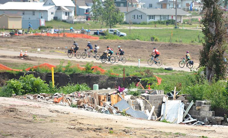 RAGBRAI riders travel through the tornado-damaged part of Greenfield last summer, where new home construction has begun.