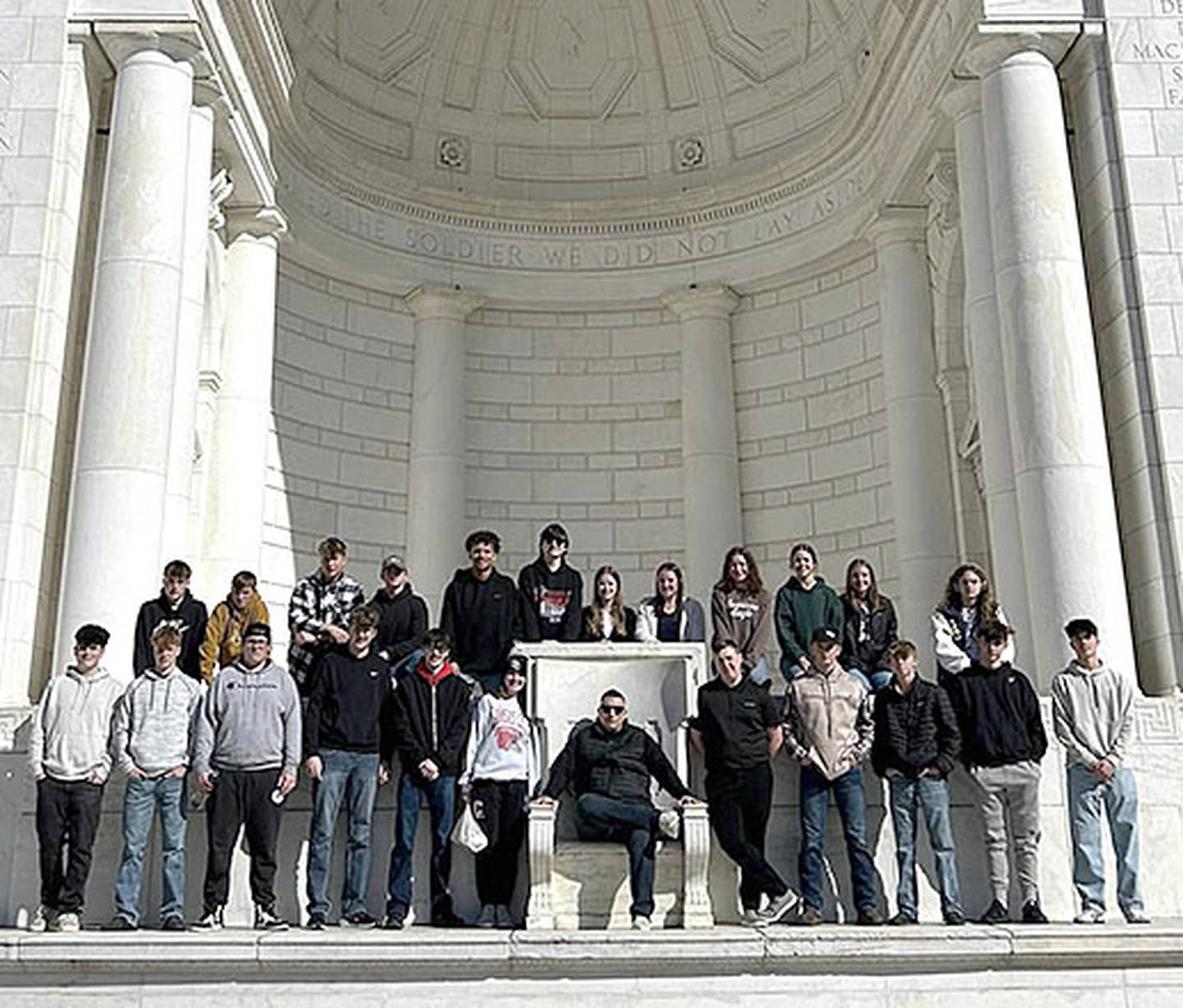Students asked teacher Todd Jacobson to sit on the "throne" at the Memorial Amphitheater at Arlington Cemetery behind the Tomb of the Unknown, after four of them participated in the wreath laying ceremony.