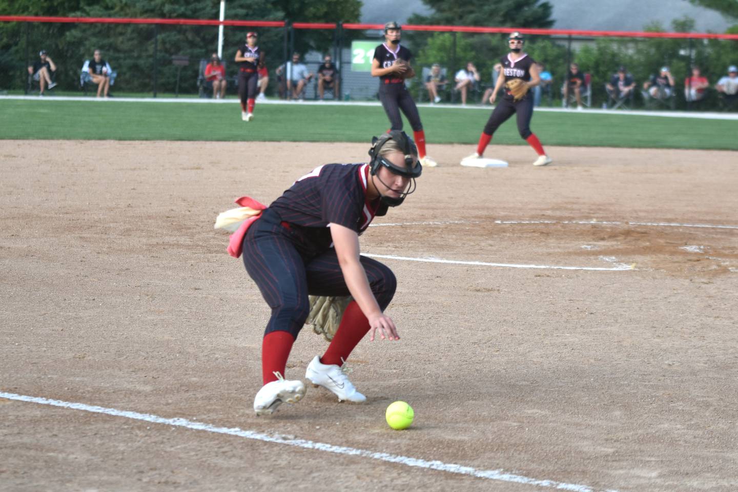 Creston pitcher Taryn Fredrickson fields a bunt against Indianola in regional play Thursday.