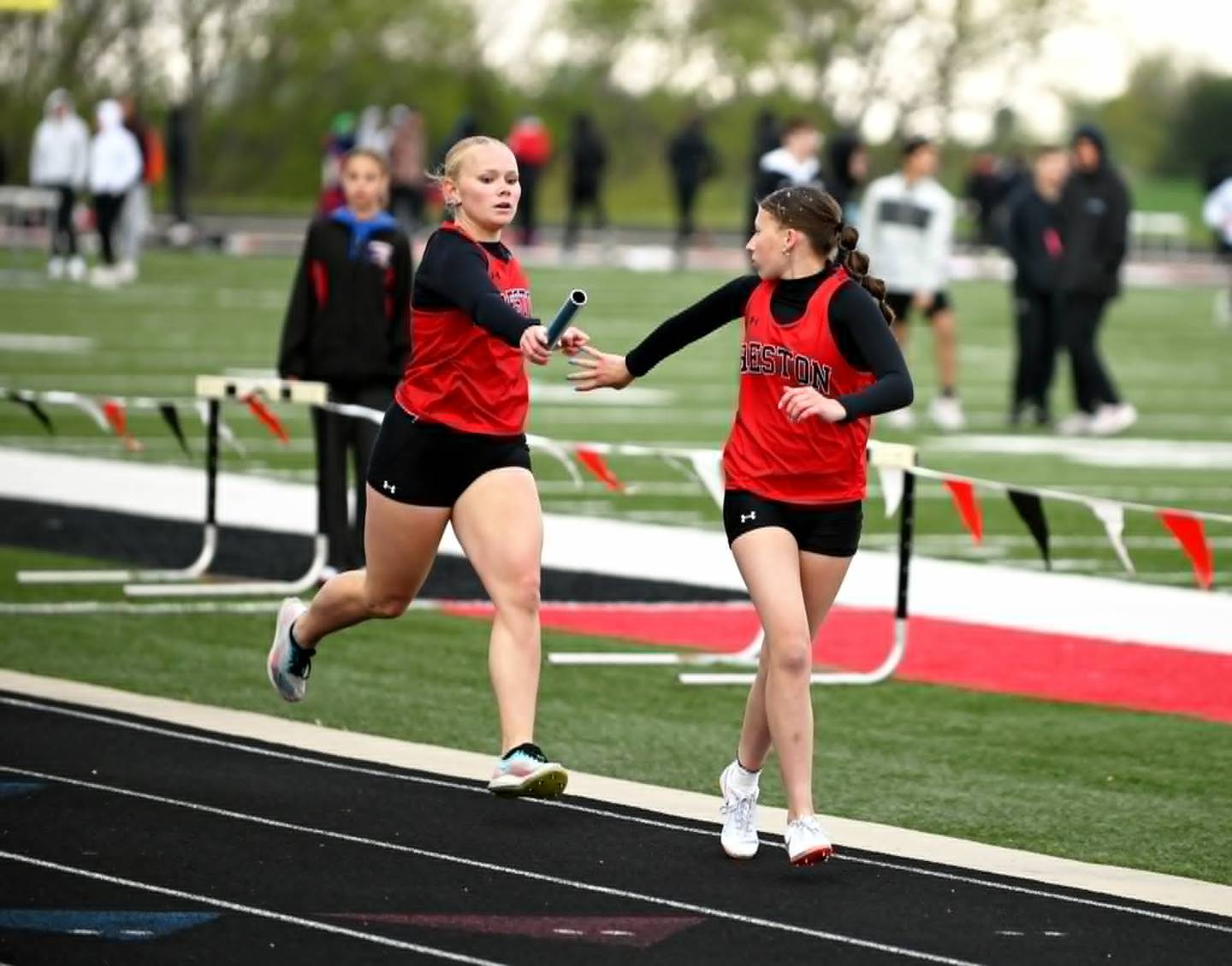 Creston's leadoff runner Maylee Riley hands the baton to Aubrey Kramer in the  winning 4x800m relay.