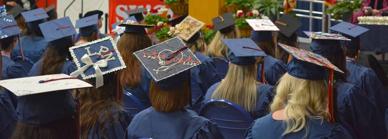 Designs on graduates' caps allude to their nursing goals achieved.
