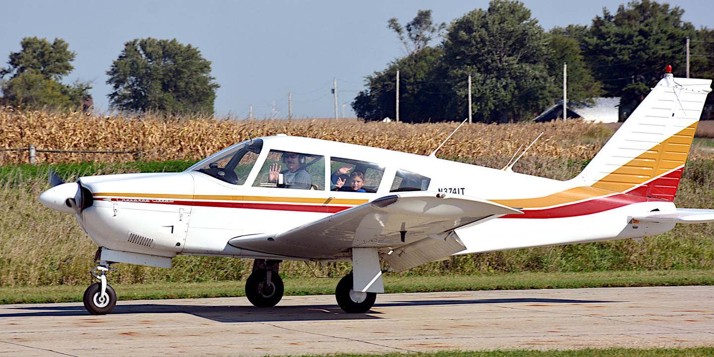 Children wave from the cockpit of an airplane Saturday after landing from a plane ride.
