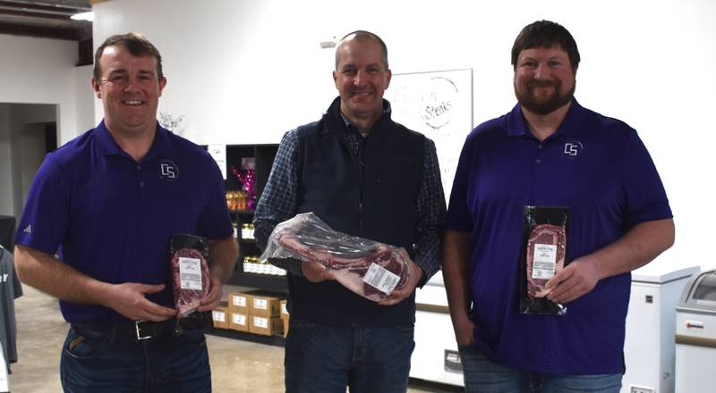 Iowa Secretary of Agriculture Mike Naig with Chad Rieck and Kyle Weaver, two of the Champion Steaks owners, during a visit to Creston last Friday.