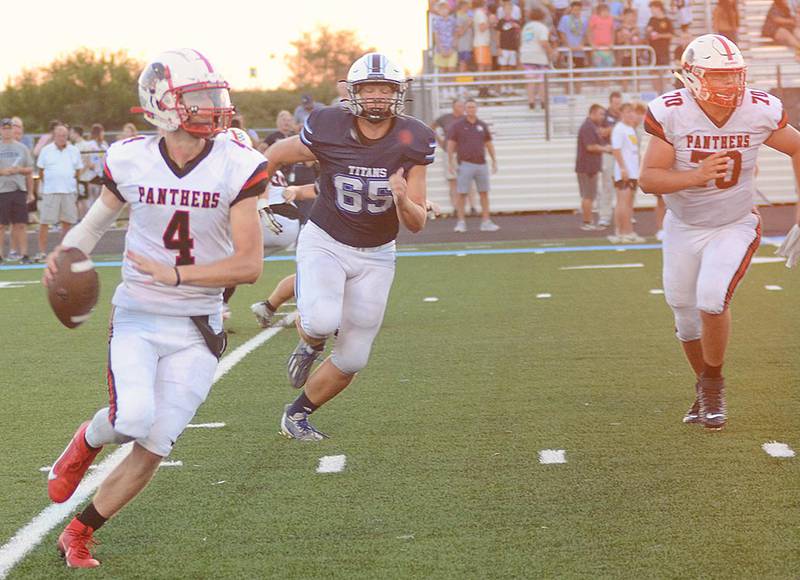 Creston quarterback Cael Turner (4) is chased by Lewis Central's Gavin Riemenschneider (65) as he looks for a receiver. Quinten Fuller (70) blocks on the play. Turner completed 14 of 26 passes for 165 yards and one touchdown.