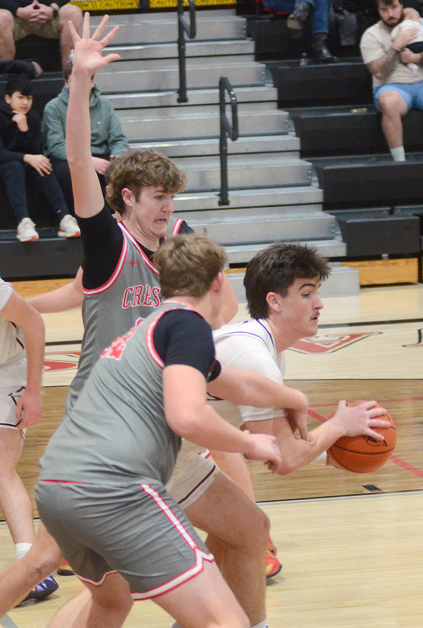 Creston's Baret Lane and Layne Sand (front) surround Clarinda senior Sam Kline, who had 25 points and five rebounds for the Cardinals Friday. Lane had three points and five rebounds.