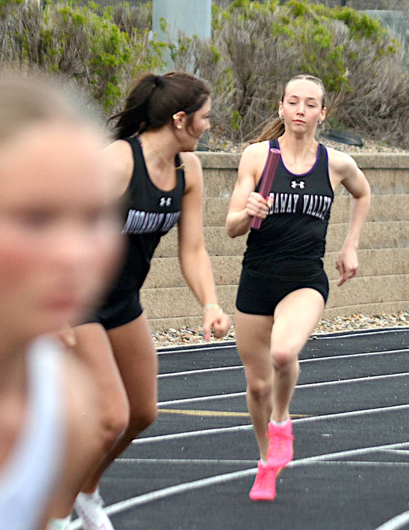 Nodaway Valley's Kylie Nelson approaches Emma Boswell on the back exchange zone during a relay at Earlham Tuesday, April 14.