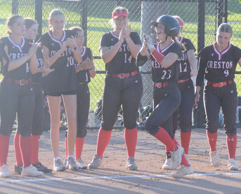 Creston second baseman Avery Staver (23) and teammates celebrate Staver's 14th home run of the season in the first inning of Tuesday's 14-1 victory over Greene County.