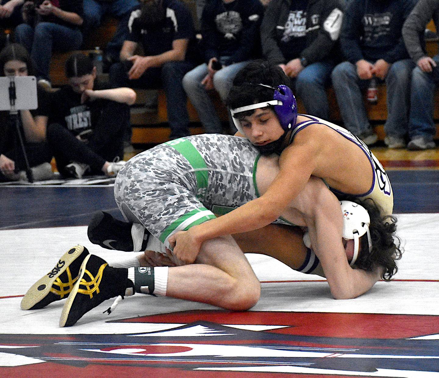 NV/OM's Keyin Steeve scoops his SEW/MD opponent's legs in an attempt to score points at district wrestling at Interstate 35.