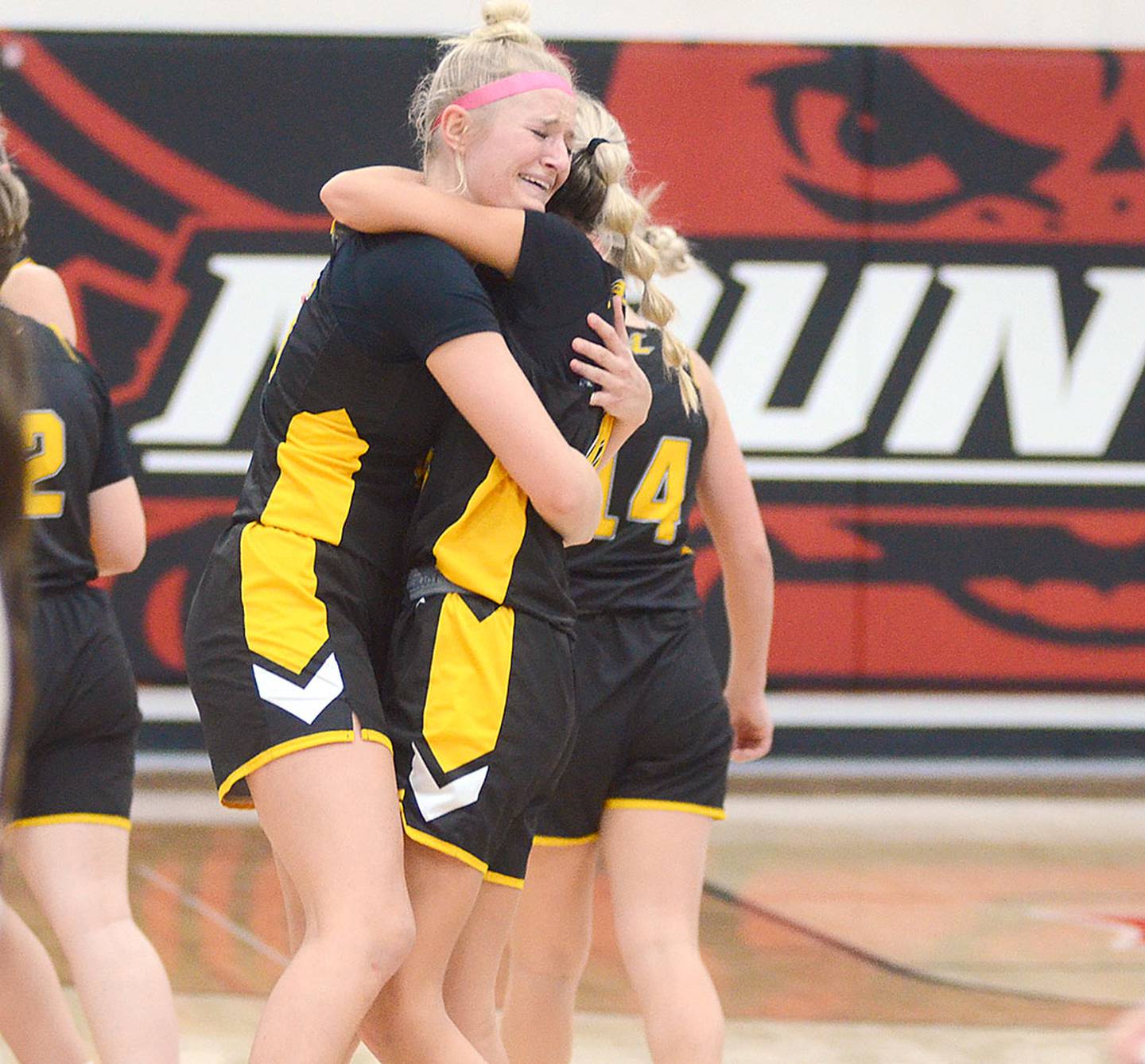 Lenox's Sadie Cox hugs teammate Zoey Reed after the Tigers defeated ninth-ranked Mount Ayr for the second time this season, 36-32, to reach Wednesday's regional final.