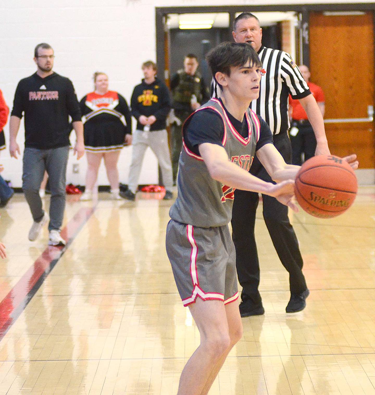 Creston senior guard Gavin Millslagle passes to a teammate as head coach Bryce Schafer surveys the action Monday. Millslagle had two assists, two rebounds and a steal in the 56-51 win.